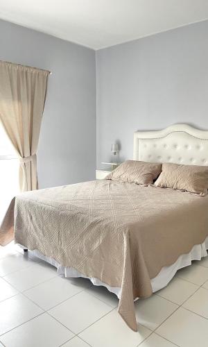 a white bedroom with a large bed and a window at COMPLEJO ECHAGUE in San Juan