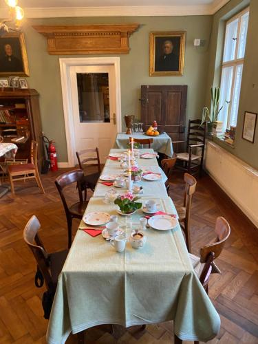 a long table with plates and candles in a room at norddeutscher Hof - Kutscherstation in Usedom Town