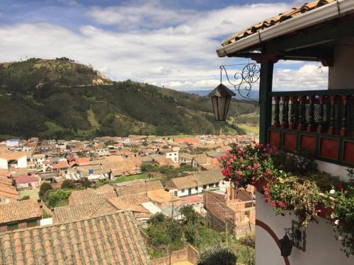 a view of a town from a balcony with flowers at Hotel Portón De Ocetá in Monguí