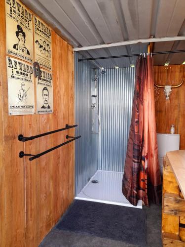 La salle de bains est pourvue d'une douche avec rideau de douche. dans l'établissement la cabane du cowboy, à Saint-Privé