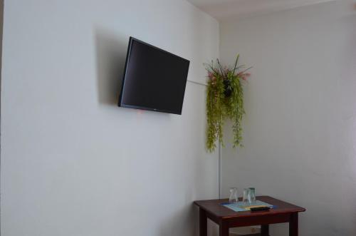 a tv hanging on a wall with a table at Penzion U parku in Rumburk
