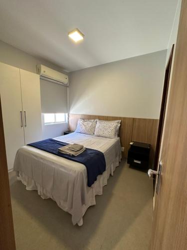 um quarto com uma cama grande com um cobertor azul em Flat em Brasília - Moderno e equipado em Brasília