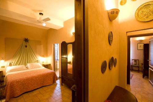 a bedroom with a bed and a room with a mirror at Antica Fattoria La Parrina in Orbetello