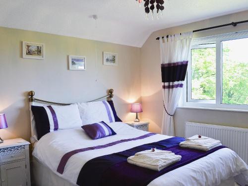 um quarto com uma cama com duas toalhas em Glennydd em Bronant