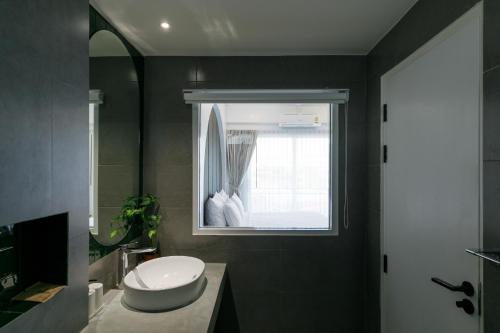 a bathroom with a white toilet and a window at Grow home -Stay and space, Self check-in in Chiang Rai