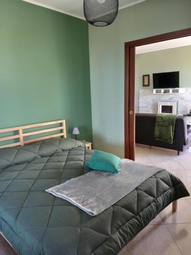 una camera con un grande letto e un soggiorno di Etna Green House a Zafferana Etnea