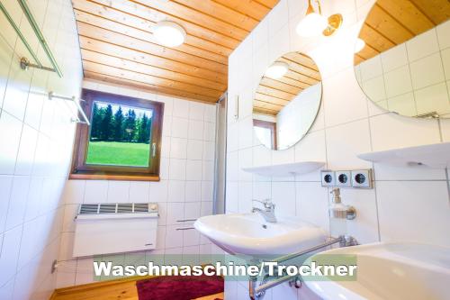 La salle de bains est pourvue d'un lavabo et d'une fenêtre. dans l'établissement Wohlfühl-Ferienwohnung 80 qm, 8 Personen, Aussicht & Heimkino, à Todtnau