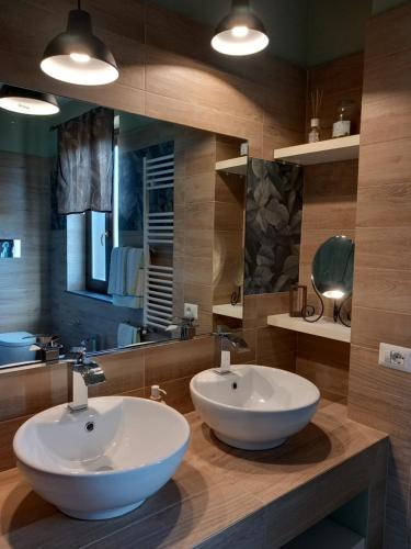 un bagno con due lavandini e un grande specchio di Etna Green House a Zafferana Etnea