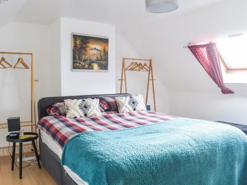 een slaapkamer met een bed met een blauwe deken bij Hobbit House in Horncliffe