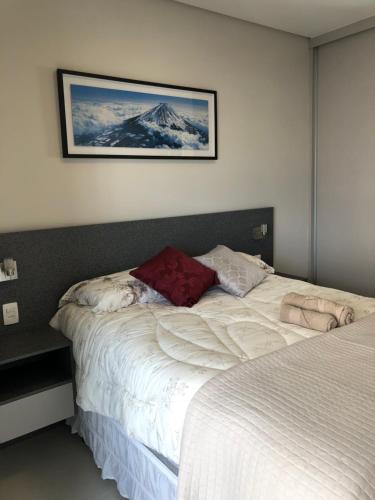 a bedroom with a bed and a picture on the wall at Monte Fuji ~ GRU 39m2 in Guarulhos