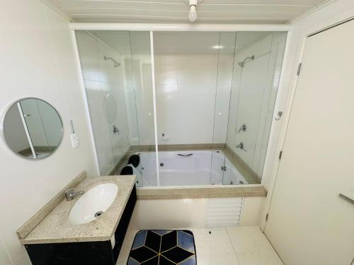 a bathroom with a shower and a sink and a tub at Nacional Hotel Coral in Lages