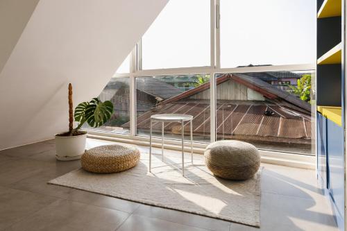 a room with two stools in front of a window at Grow home -Stay and space, Self check-in in Chiang Rai