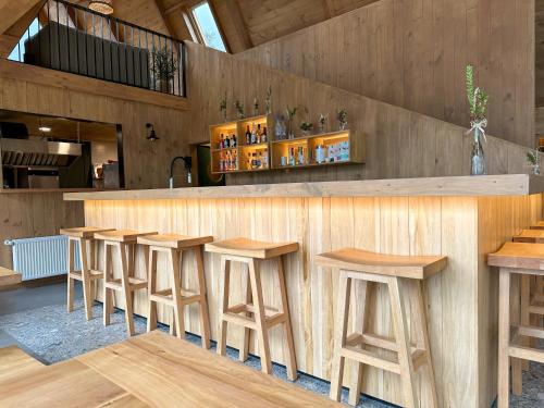 um bar com bancos de madeira num restaurante em Tawa Refugio del Puelo em Puelo