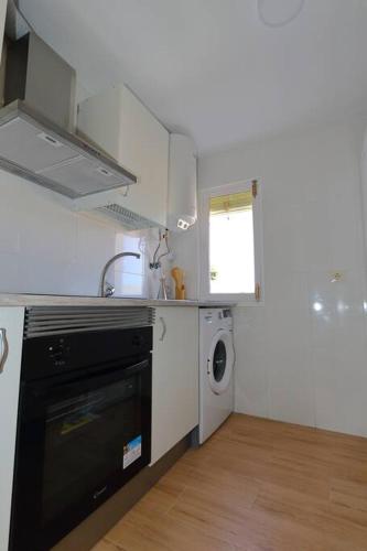 a kitchen with a black dishwasher and a washer at AMORE MÍO Hellín in Hellín