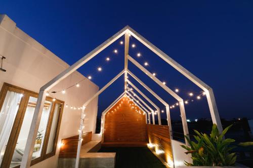 a house with lights on the roof at night at Grow home -Stay and space, Self check-in in Chiang Rai