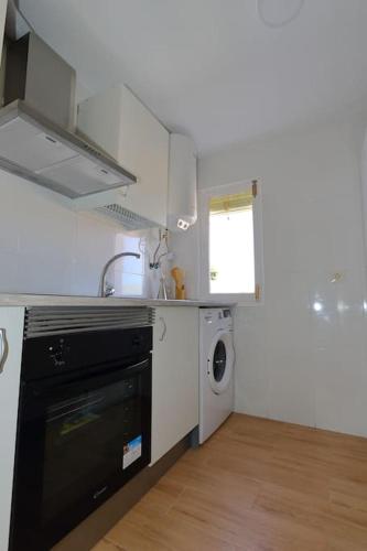 a kitchen with a black dishwasher and a washing machine at AMORE MÍO Hellín in Hellín
