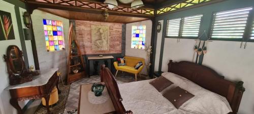 a bedroom with a bed and a table and a chair at Fleur de vanille in Le Tampon