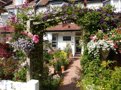 an arch with flowers in front of a house at Belle Dene Guest House in Paignton