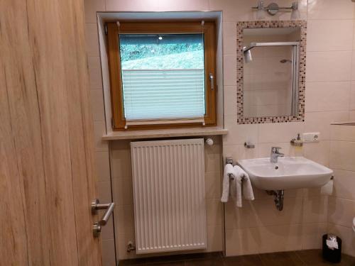 a bathroom with a sink and a window at Ferienwohnungen Haus Moser in Berchtesgaden