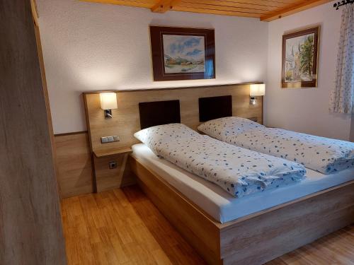 um quarto com uma cama e uma cabeceira em madeira em Ferienwohnungen Haus Moser em Berchtesgaden