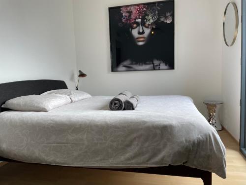 Un dormitorio con una cama con una fotografía de una mujer. en Appartement d'exception - Vue panoramique sur lac, en Évian-les-Bains