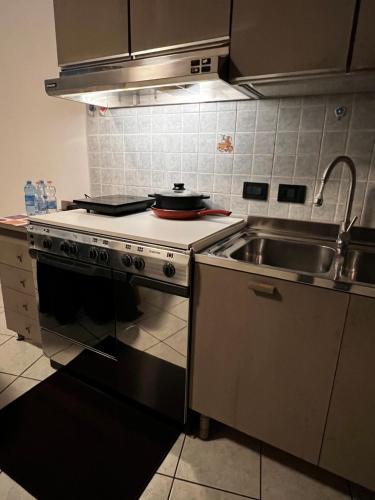 a kitchen with a stove and a sink at Come a casa tua in Falconara Marittima