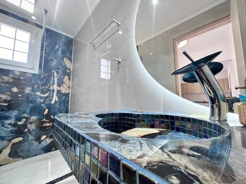 a bathroom with a tub with a fountain in it at Nikos Apartments Corfu in Agios Stefanos