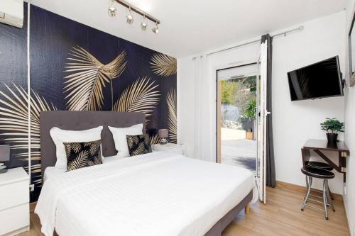 エズにあるStudio au calme, avec terrasse et parking à Eze villageのベッドルーム1室(白いベッド1台、ガラスのスライドドア付)