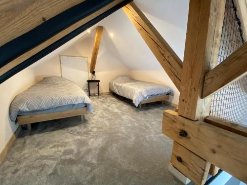 um quarto no sótão com 2 camas e uma escada em Cocon Pontissalien em Pontarlier