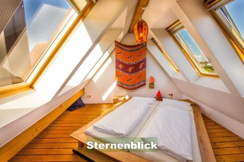 an attic room with a bed and windows at Ferienhaus Schwarzwald bei Straßburg Europapark für 12 Personen auf 160qm in Rheinau