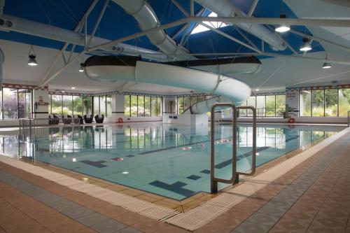 uma grande piscina interior com água em The Lakeside Hotel & Leisure Centre em Killaloe