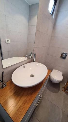 a bathroom with a white sink and a toilet at Bright Studio in Shapira in Tel Aviv