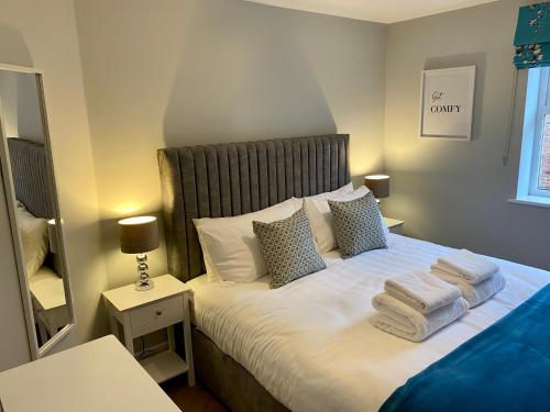 1 dormitorio con 1 cama con toallas en Luxury Riverside City Centre Apartment, en York