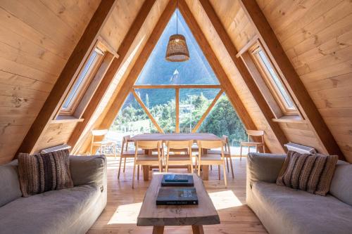 a dining room with a table and a large window at Tawa Refugio del Puelo in Puelo