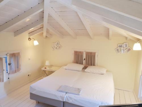 a bedroom with a large white bed in a room at Private Swimmingpool in Cottage in Poros