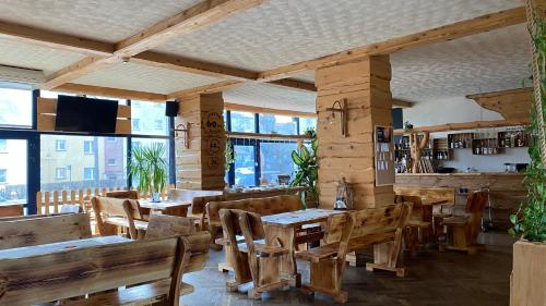 サノクにあるDom Turysty Sanokの木製のテーブルと椅子、窓のあるレストラン
