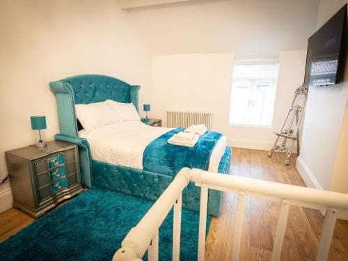 a bedroom with a bed with a blue headboard at Cottage Buttercup Yarm in Stockton-on-Tees