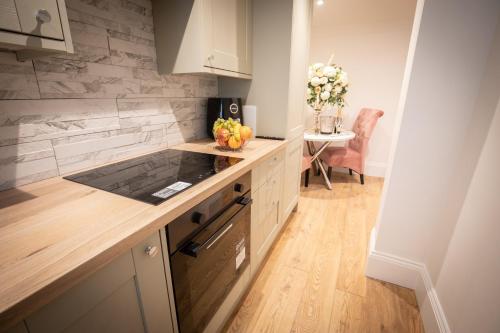 a kitchen with a counter and a table with a vase of flowers at Cottage Buttercup Yarm in Stockton-on-Tees