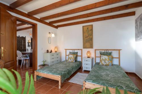 een slaapkamer met 2 bedden in een kamer bij Beautiful Boho Glam Villa With Private Pool in Playa Blanca