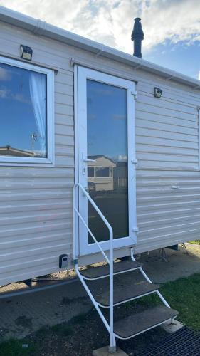 an open door of a mobile home with a staircase at Seawick Holiday Park in Saint Osyth