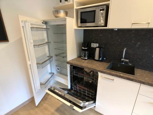 a kitchen with an open refrigerator and a microwave at Luxuriöse Ferienwohnung in Chemnitz - Apartment B28 für 2 plus 2 Gäste in Chemnitz
