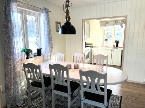 a dining room with a white table and chairs at Mysigt fritidshus och annex med eget sjöläge! in Torsby