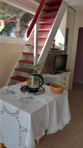une table avec un tissu de table blanc et un escalier dans l'établissement Charmant petit Studio en duplex, à Le Fenouiller