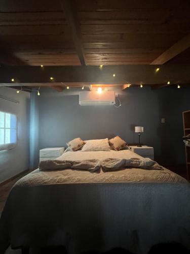 1 dormitorio con 1 cama grande y pared azul en Departamento Pellegrini en Tandil