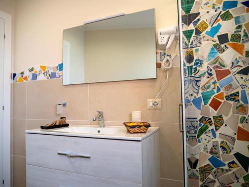 y baño con lavabo y espejo. en Sicilia Bedda - B&B - Rooms - Apartments, en Santo Stefano di Camastra