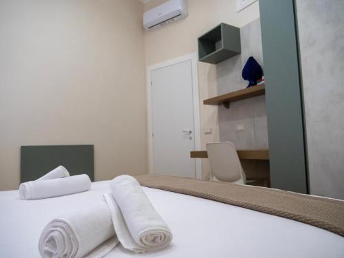 a bedroom with a white bed with towels on it at Sicilia Bedda - B&B - Rooms - Apartments in Santo Stefano di Camastra