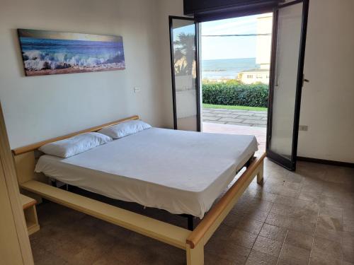 ein Schlafzimmer mit einem Bett in einem Zimmer mit einem Fenster in der Unterkunft OrtonaAmareAppartamenti in Ortona