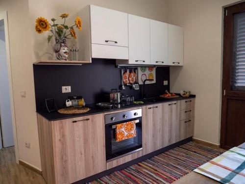 a kitchen with white cabinets and an oven at Sicilia Bedda - B&B - Rooms - Apartments in Santo Stefano di Camastra