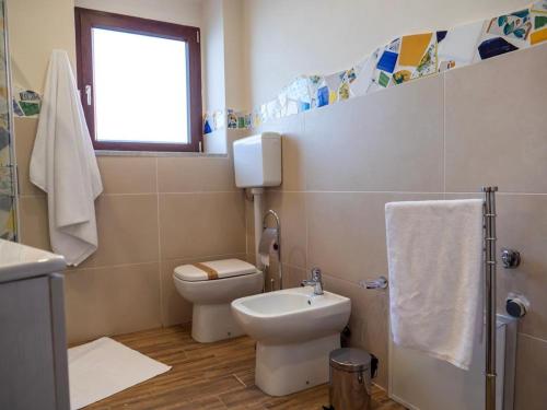 a bathroom with a toilet and a sink at Sicilia Bedda - B&B - Rooms - Apartments in Santo Stefano di Camastra