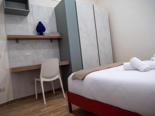 a bedroom with a bed and a chair in it at Sicilia Bedda - B&B - Rooms - Apartments in Santo Stefano di Camastra